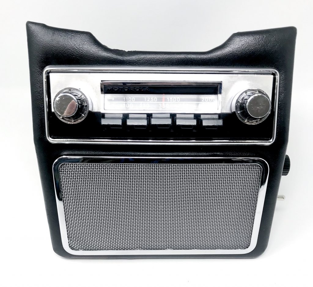 Aston Martin DB6 radio console showing restored Motorola 727 radio and chrome speaker grille - front